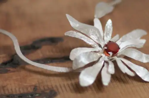 Silbercollier (UNIKAT) "Blume" mit Stein aus Hessonit auf Holzfläche
